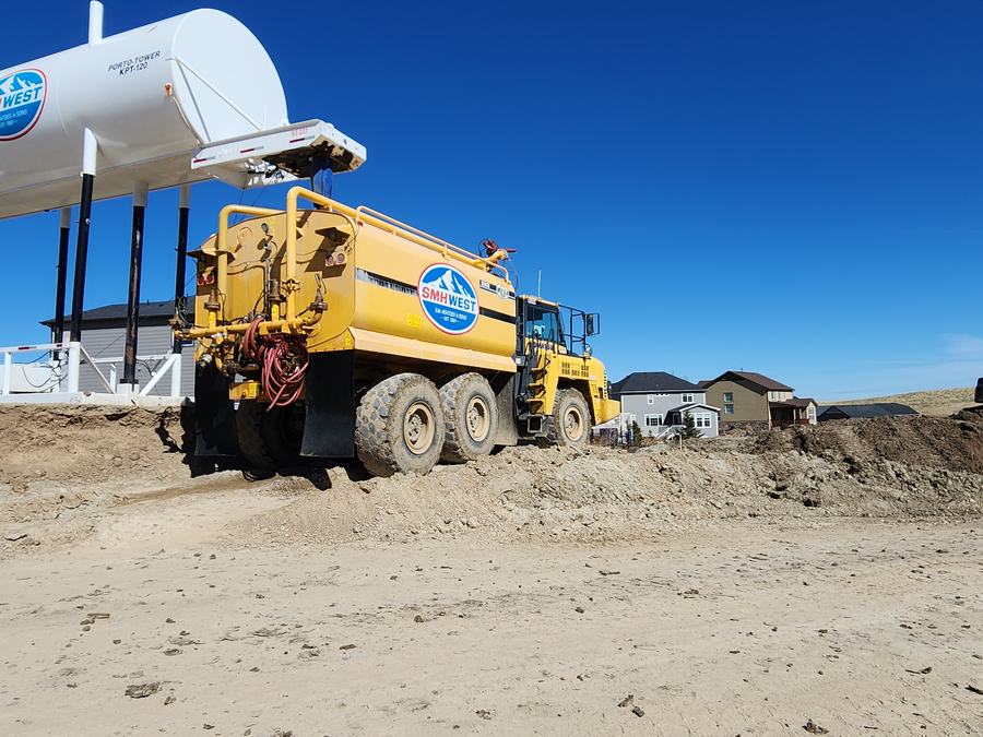SMH West water truck filling from a tank on a jobsite